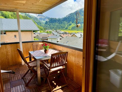a porch with a table and chairs on a balcony at Ferienwohnung Schoppernau in Schoppernau
