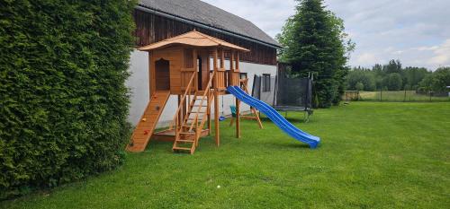a playground with a slide and a play house at Domek Góralski zakątek Czerwienne in Czerwienne