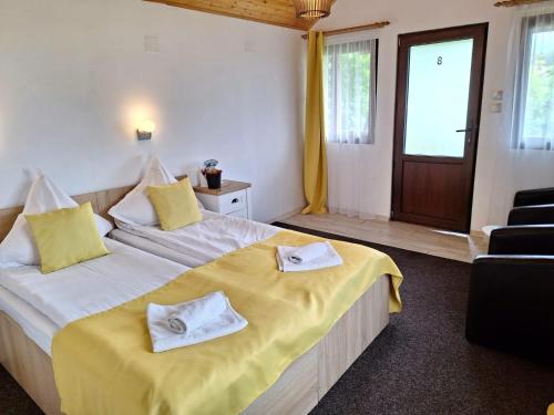a bedroom with a large bed with towels on it at Chalet Tinelu Brașov Săcele in Săcele