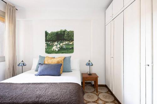 1 dormitorio con 1 cama y una pintura en la pared en 2 Bdr Apt In Cornella 5 Mins Form The Metro, en Cornellà de Llobregat