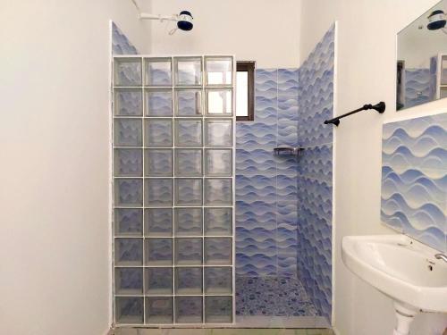 y baño con ducha de azulejos azules. en Jamiitown Homes en Kilifi