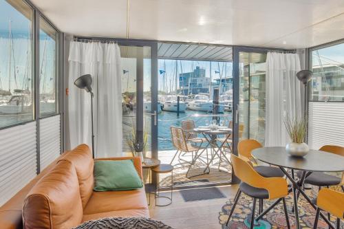 a living room with a couch and a table and chairs at Hausboot - Kleine Auszeit in Heiligenhafen