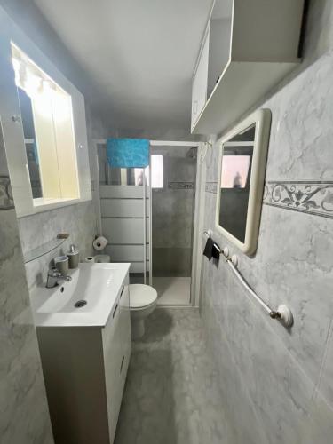 a bathroom with a white sink and a toilet at Apartament Mar Bella Azul in Miramar