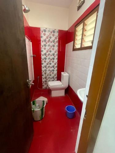 a red bathroom with a toilet and a sink at Temple View Home Stay in Tiruvannāmalai