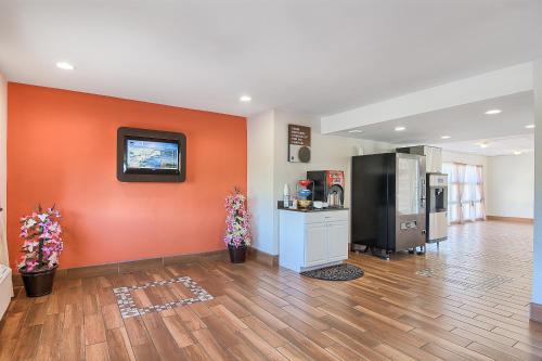 a room with an orange wall with a refrigerator at Motel 6-Harrisonburg, VA - South in Harrisonburg