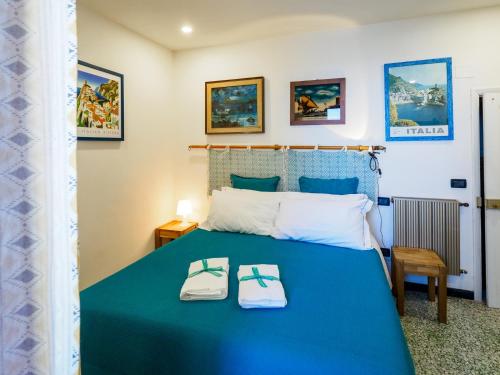ein Schlafzimmer mit einem blauen Bett und zwei Hausschuhen darauf in der Unterkunft Ventu de Ma in Vernazza
