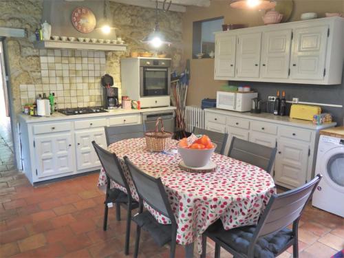 une cuisine avec une table avec un bol de fruits dessus dans l'établissement Holiday Home La Raze by Interhome, à Bonneville-et-Saint-Avit-de-Fumadières