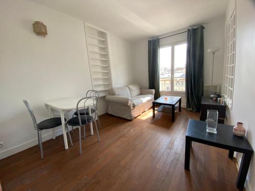 un salon avec une table et un canapé dans l'établissement Batignolles toits de paris, à Paris