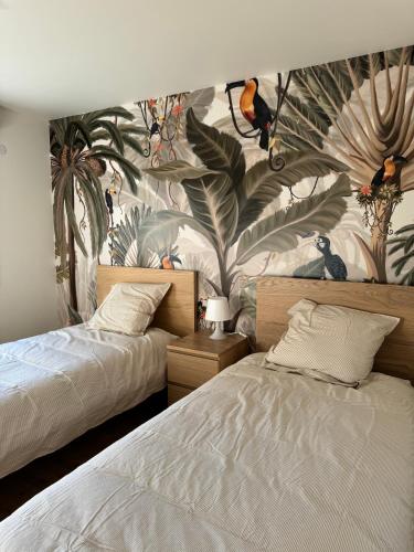 - une chambre avec 2 lits et un papier peint tropical dans l'établissement Elégante maison de ville rénovée, à Toulouse