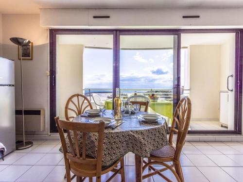 une salle à manger avec une table et des chaises et un balcon dans l'établissement Apartment Les Roches Marines-3 by Interhome, au Cap d'Agde