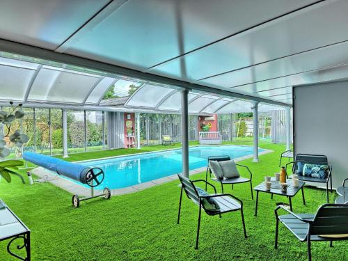 a living room with a pool with chairs and a blue slide at Holiday Home La belle étape by Interhome in Cherrueix