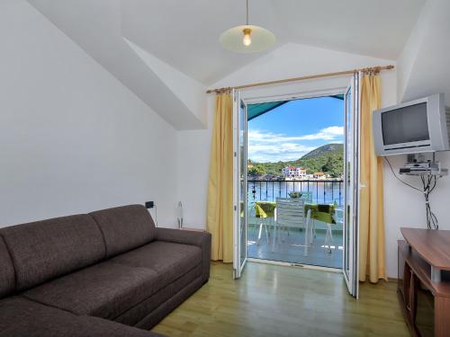a living room with a couch and a sliding glass door at Apartment Rubin-8 by Interhome in Zastražišće