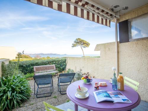 Una mesa y sillas moradas en un patio con vista. en Apartment Les Louvans-6 by Interhome, en Saint-Aygulf