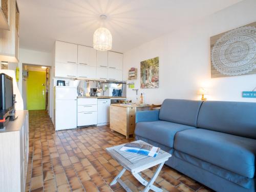 un salon avec un canapé bleu et une cuisine dans l'établissement Apartment Les Louvans-6 by Interhome, à Saint-Aygulf
