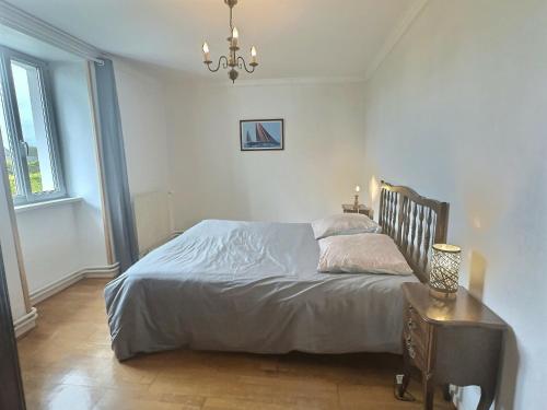 a bedroom with a bed and a table and a chandelier at Villa ocean in Loctudy