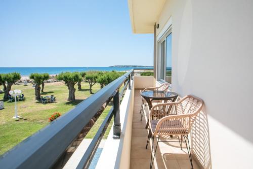a balcony with chairs and a table and a view of the ocean at Al Mare Apartments in Afantou