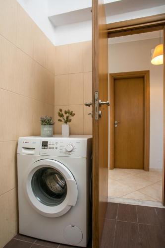 a washing machine in a room with a door at Al Mare Apartments in Afantou