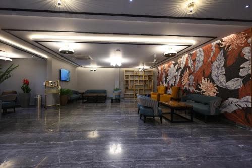 a lobby with chairs and a wall with a flower mural at The Oaks Elite in Gulbarga