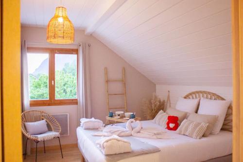 - une chambre avec un grand lit blanc recouvert de cygnes dans l'établissement Une Oasis de détente, à Gilly-sur-Isère