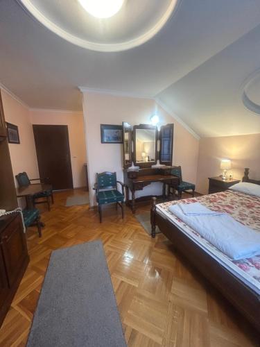 a bedroom with a bed and a mirror and a desk at Konačište Osmica in Mokra Gora