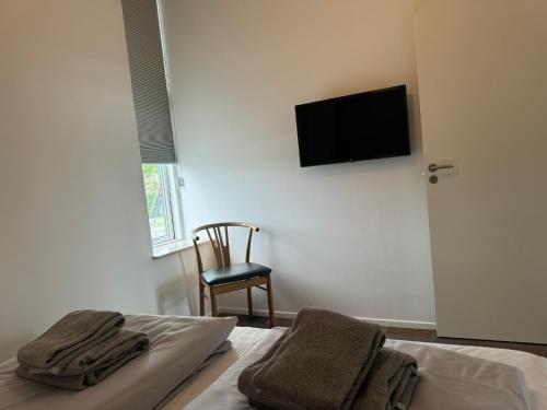 a bedroom with a bed and a television on the wall at Hvide Sande Hotel in Hvide Sande