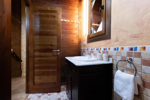 ein Bad mit einem Waschbecken und einem Spiegel in der Unterkunft Apartamentos Rurales San Feliz in Pola de Lena