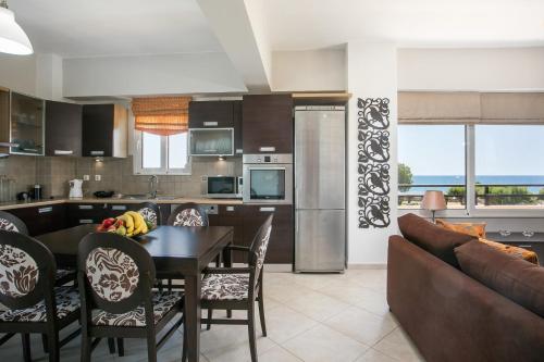 kuchnia i salon ze stołem i krzesłami w obiekcie Al Mare Apartments w mieście Afandu