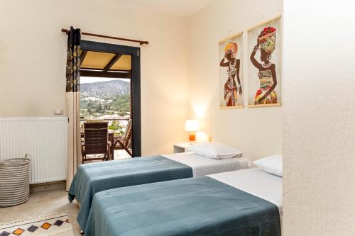 a room with two beds and a window with a view at Marina View Syvota in Sivota