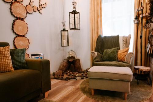 a living room with two chairs and a ottoman at A kégli in Háromhuta