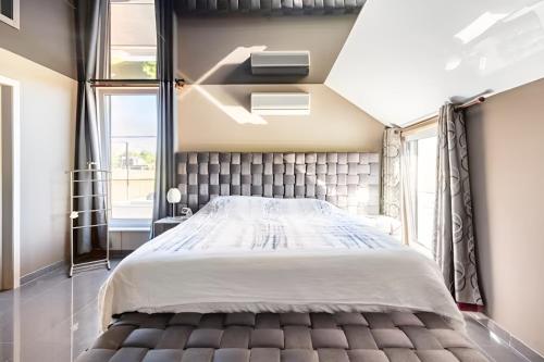 a bedroom with a large bed and a window at LA VILLA DE SENY , villa de charme avec jardin ,Piscine nature, jacuzzi , petanque, fitness, billard,ping pong, in Seny