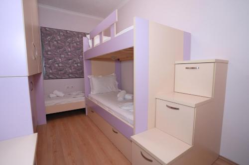 um pequeno quarto com um beliche e uma escada em “apHEARTment Gjirokastra” em Gjirokastër