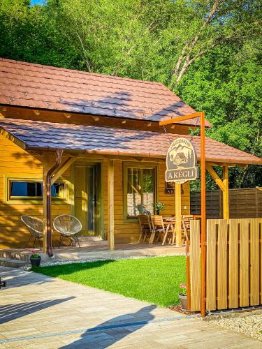 a wooden cabin with a sign in front of it at A kégli in Háromhuta