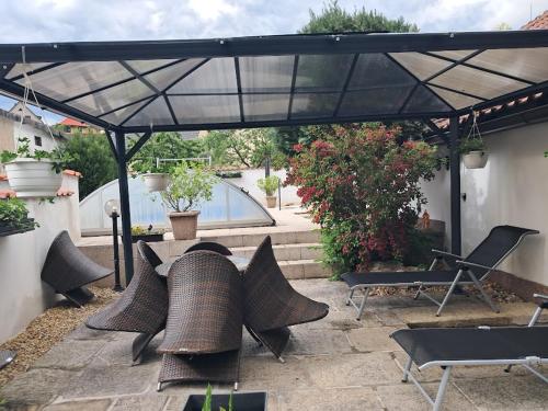 a patio with a table and chairs under a black umbrella at Jaroslav Ambrož Elvomont Chlum u Třeboně in Chlum u Třeboně