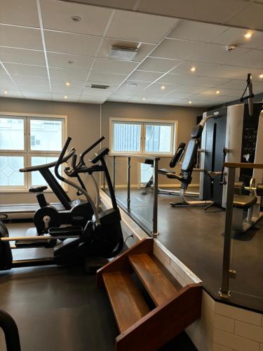 a gym with treadmills and elliptical machines at Home Hotel Plaza in Karlstad