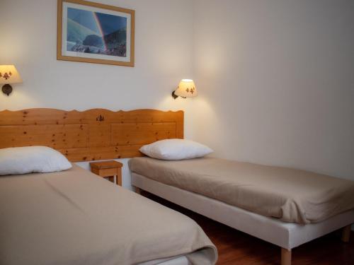 twee bedden in een kamer met twee lampen aan de muur bij Appartement Le Dévoluy, 2 pièces, 4 personnes - FR-1-504-488 in Superdevoluy