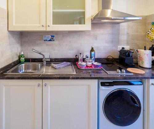 a kitchen with a sink and a washing machine at Ventu de Ma in Vernazza