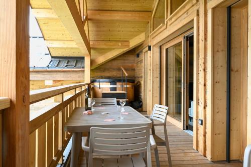 une terrasse en bois avec une table et des chaises dessus dans l'établissement Apartment Pinnacle, aux Gets