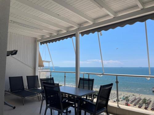 une terrasse avec une table et des chaises et l'océan dans l'établissement Blumont Aparthotel Durres, à Durrës