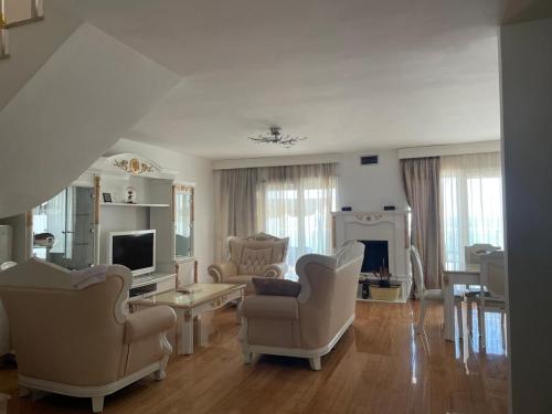 duży salon z krzesłami i telewizorem w obiekcie Blumont Aparthotel Durres w Durrës