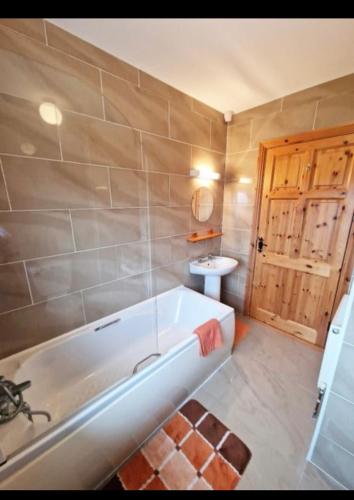 a bathroom with a bath tub and a sink at Sunset view Homestay in Milltown Malbay