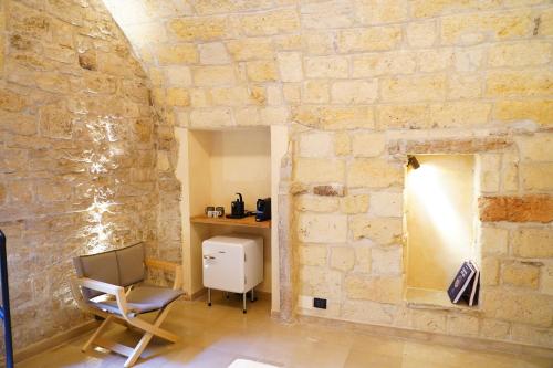 a room with a chair and a stone wall at Terra di Trani in Trani
