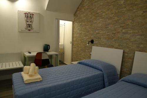 a bedroom with two beds and a brick wall at Il sogno dei mori in Ragusa