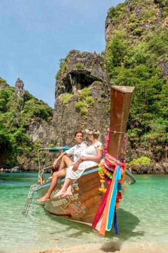 a man and woman sitting on a boat in the water at Phi Phi Maiyada Resort in Phi Phi Don