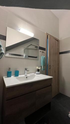 a bathroom with a white sink and a mirror at Casa di Giovanna in Volos