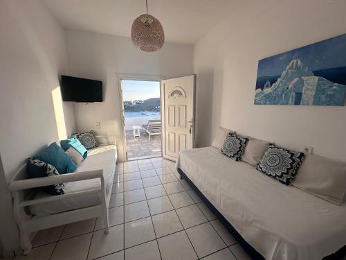 a living room with a couch and a chair and a door at Revel Mykonos 3 in Ornos