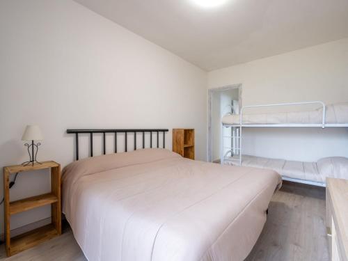 a white bedroom with a bed and bunk beds at Apartment Tenuta Rucas by Interhome in Montoso