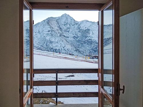 an open door with a view of a snow covered mountain at Apartment Tenuta Rucas by Interhome in Montoso