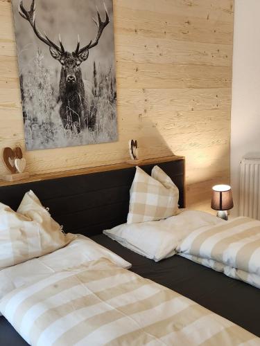 two beds in a room with a picture of a deer at Haus Martina in Sand in Taufers