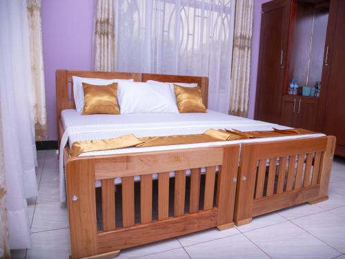 a wooden bed with a wooden frame in a room at Aminata Homes & Apartment in Moshi