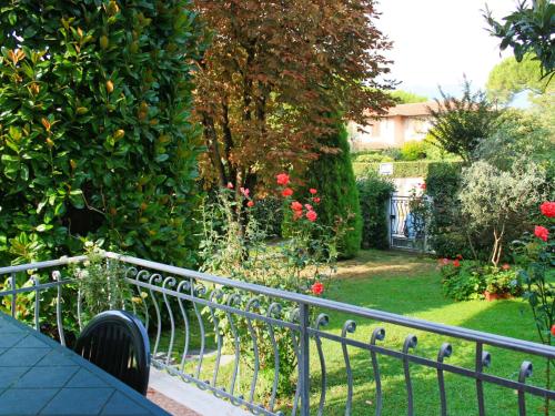 een uitzicht op een tuin met een hek en bloemen bij Holiday Home Nannini by Interhome in Forte dei Marmi